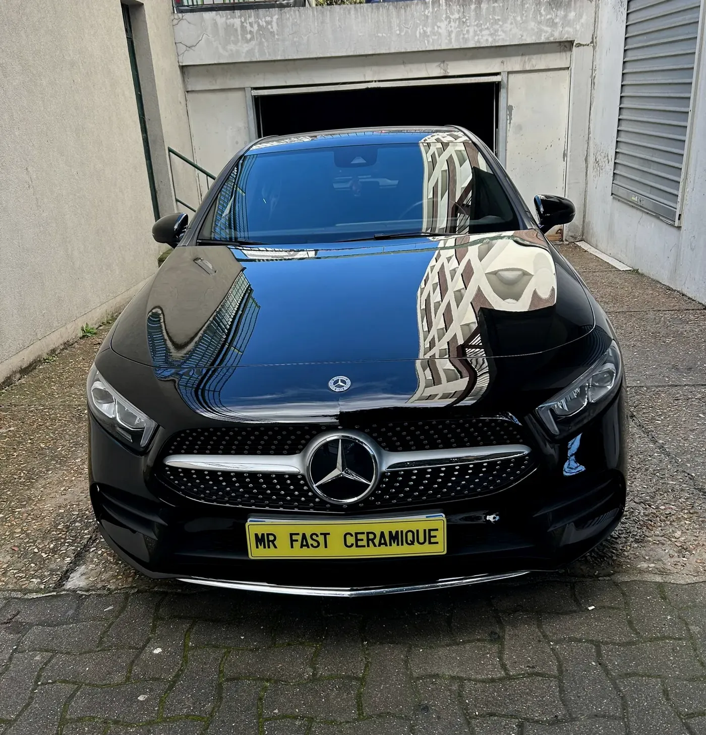 Carrosserie noire polie reflétant les lumières de l’atelier